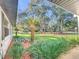 Landscaped front yard with lush greenery and mature trees providing shade at 9050 Sw 190Th Cir, Dunnellon, FL 34432