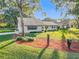 Ranch home with nicely landscaped yard, featuring red mulch beds and mature trees at 9050 Sw 190Th Cir, Dunnellon, FL 34432