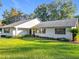 White one-story house with gray roof and manicured lawn at 9050 Sw 190Th Cir, Dunnellon, FL 34432