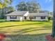 White house with gray roof, landscaping, and driveway at 9050 Sw 190Th Cir, Dunnellon, FL 34432