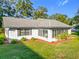 White house with gray roof, screened porch, and landscaping at 9050 Sw 190Th Cir, Dunnellon, FL 34432