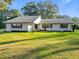 White house with gray roof, landscaping, and driveway at 9050 Sw 190Th Cir, Dunnellon, FL 34432