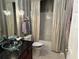 Small bathroom with a shower/tub combo, glass sink, and dark vanity at 13300 Se 97Th Terrace Rd, Summerfield, FL 34491