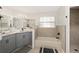 Updated bathroom with gray vanity, tile shower, and bathtub at 13740 Sw 49Th Pl, Ocala, FL 34481