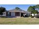 One-story house with red shutters, landscaping, and driveway at 15440 Sw 14Th Avenue Rd, Ocala, FL 34473