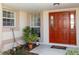 Inviting front entrance with a red door and potted plants at 15440 Sw 14Th Avenue Rd, Ocala, FL 34473