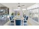Sunlit dining room with white table and blue chairs, overlooking pool at 15692 Sw 11Th Court Rd, Ocala, FL 34473