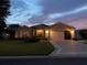Tan one-story house with a two-car garage and landscaping at 15692 Sw 11Th Court Rd, Ocala, FL 34473