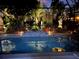 Inviting pool at night with colorful lighting and lush landscaping at 15692 Sw 11Th Court Rd, Ocala, FL 34473