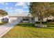 White single story home with attached garage and well-manicured lawn at 1616 San Diego St, The Villages, FL 32159