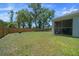 Spacious fenced backyard featuring a well-maintained lawn, trees, and a screened patio at 1664 Sw 167Th St, Ocala, FL 34473
