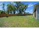 View of the fenced in backyard and back of the home, complete with lawn and trees at 1664 Sw 167Th St, Ocala, FL 34473