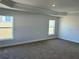 Spacious bedroom with tray ceiling, carpet, and abundant natural light from the two windows at 2142 Nw 23Rd Loop, Ocala, FL 34475