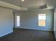 Bedroom featuring tray ceiling, plush carpeting, and a glass panel door to the backyard at 2142 Nw 23Rd Loop, Ocala, FL 34475