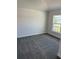 This is a clean, carpeted bedroom with a window offering a view of the outdoor landscape and white trim at 2146 Nw 23Rd Loop, Ocala, FL 34475