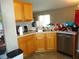 Galley kitchen with wood cabinets, double sink, and dishwasher at 221 Locust Ln, Ocala, FL 34472