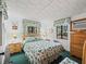 Cozy bedroom with leafy patterned bedding, wood dresser, and two windows at 3041 S Us Highway 41, Dunnellon, FL 34432