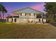 Evening view of two-story house with columns and lit windows at 4343 Nw 80Th Ave # 4, Ocala, FL 34482