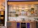 Well-appointed bar area featuring custom shelving, a wine fridge and a unique, artistic backsplash at 4400 Sw 20Th Ave, Ocala, FL 34471