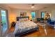 Cozy bedroom with hardwood floors, ceiling fan, and sliding mirrored closet at 4400 Sw 20Th Ave, Ocala, FL 34471