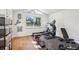 Bright home gym featuring hardwood floors, various exercise machines, and natural light from a large window at 4400 Sw 20Th Ave, Ocala, FL 34471