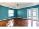 Blue bedroom with wood floors and sliding glass doors at 4542 Ne 4Th St, Ocala, FL 34470