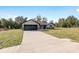 Modern one-story home with a dark gray roof and a two-car garage at 61 Water Track Loop, Ocala, FL 34472