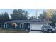 Blue house with solar panels and a white garage door at 6701 Se 122Nd Ln, Belleview, FL 34420