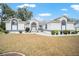Charming single-story home with white exterior, blue trim, landscaped yard, and arched windows at 7528 Sw 102Nd Loop, Ocala, FL 34476