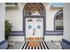Close up of the front double doors showing wreath details, a striking door mat, and ornate lighting fixture at 7528 Sw 102Nd Loop, Ocala, FL 34476