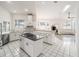 Bright eat-in kitchen featuring white cabinets, stainless steel appliances, and an island with a dark countertop at 7528 Sw 102Nd Loop, Ocala, FL 34476