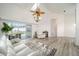 Open-concept living room with neutral tones, high ceilings, laminate flooring, and sliding glass door at 7528 Sw 102Nd Loop, Ocala, FL 34476