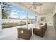 Relaxing screened-in patio featuring wicker seating and a view of the backyard with manicured landscaping at 7528 Sw 102Nd Loop, Ocala, FL 34476