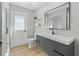 Modern bathroom with gray vanity, frameless shower, and wood-look tile floor at 7675 W Highway 326, Ocala, FL 34482