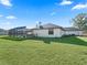 Single-story home with a large backyard, lush grass, and a screened pool at 7675 W Highway 326, Ocala, FL 34482