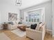 Bright living room with hardwood floors, large windows, and comfortable sofas at 7675 W Highway 326, Ocala, FL 34482