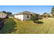 Home features a large backyard with grassy lawn, manicured hedges, and a spacious screened patio at 8086 Sw 81St Loop, Ocala, FL 34476
