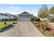 Gray house with white garage door and landscaped yard at 8405 Sw 82Nd Loop, Ocala, FL 34481