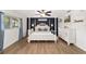Main bedroom with a four-poster bed, wood-look floors, and an accent wall at 8580 Sw 97Th Lane Rd # B, Ocala, FL 34481