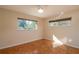 Bright bedroom with hardwood floors, ceiling fan, and large windows at 8653 Sw 96Th St # A, Ocala, FL 34481