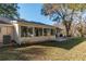 Back exterior view showing sunroom addition and landscaping at 8653 Sw 96Th St # A, Ocala, FL 34481