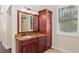 Bathroom with granite countertop, wood cabinet, and large mirror at 995 Sw 37Th Place Rd, Ocala, FL 34471