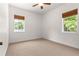 Bedroom with two windows, ceiling fan and carpet at 10320 Sw 103Rd Ct, Ocala, FL 34481