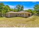 Single-story house with beige siding, large backyard, and patio at 10320 Sw 103Rd Ct, Ocala, FL 34481