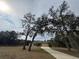 House with a long driveway, framed by large trees at 1060 Sw Big Tree Rd, Dunnellon, FL 34431