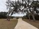 House with a long driveway, framed by large trees at 1060 Sw Big Tree Rd, Dunnellon, FL 34431