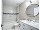 Updated bathroom with white vanity, marble countertop, and large mirror at 10856 Sw 79Th Ave, Ocala, FL 34476