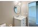 Modern bathroom featuring a white vanity and a round mirror at 10856 Sw 79Th Ave, Ocala, FL 34476