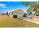 Attached garage with a paved driveway and neat landscaping at 11518 Sw 136Th Pl, Dunnellon, FL 34432