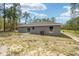 Home's back features a sliding glass door and a large backyard at 117 Nw Sparrow Rd, Dunnellon, FL 34431